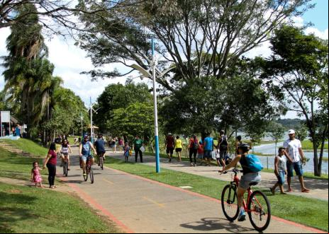 parque com ciclovia e pessoas caminhando e pedalando